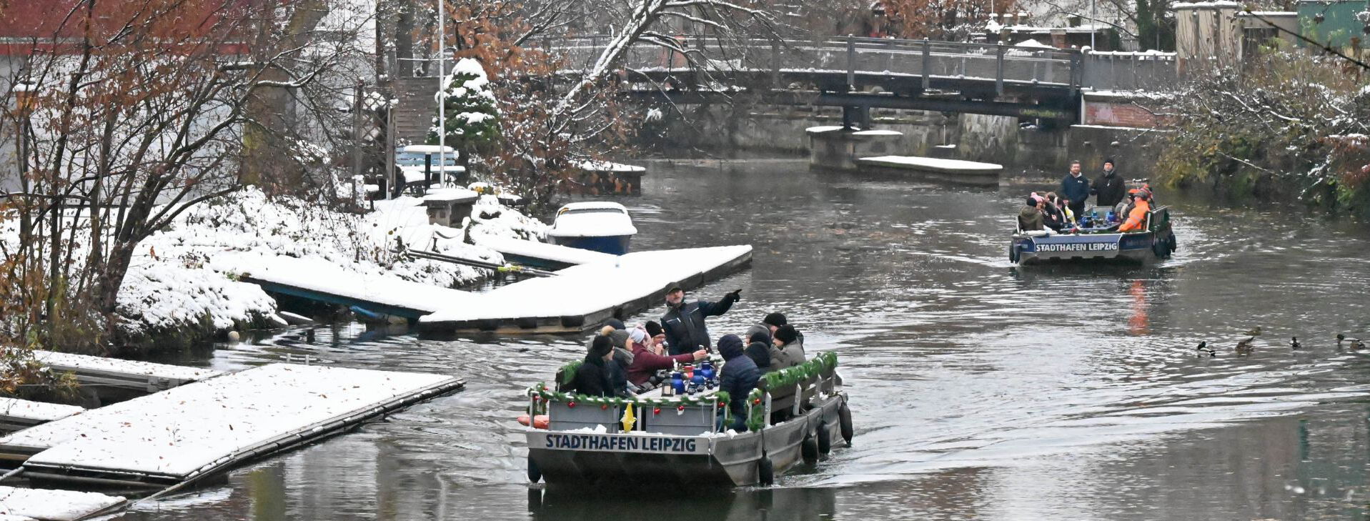 Zwei Motorboote fahren im Winter durch die Leipziger Kanäle.