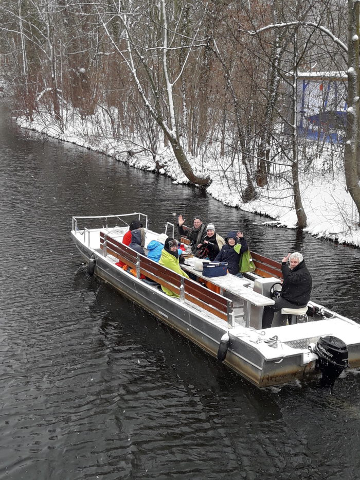 Ein Motorboot fährt im Winter durch die Leipziger Kanale.