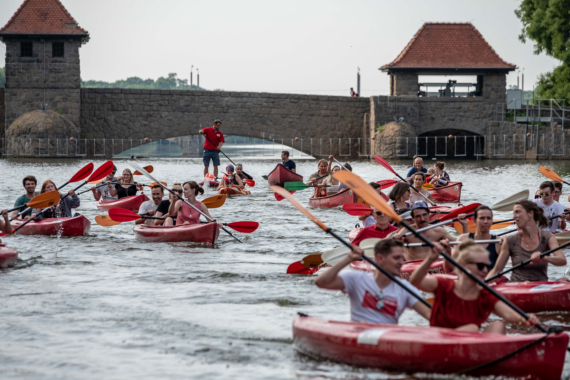 Eine Gruppe Menschen fährt mit mehreren Kanus durch die Leipziger Kanäle.